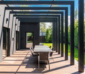 J'installe une pergola adossée avec voile d'ombrage sur ma terrasse pour créer un espace convivial.